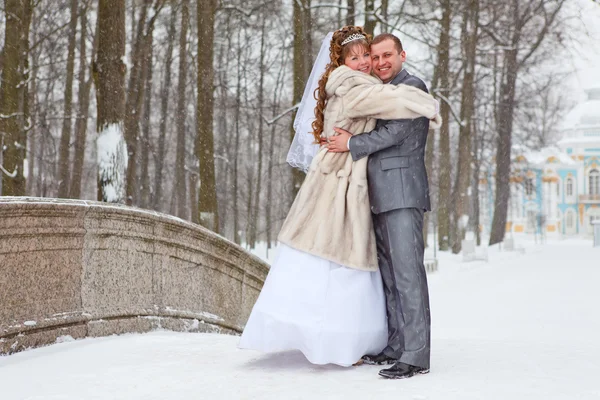 Молодая брачная русская пара, обнимающаяся в снежном парке. Зимний сезон в России — стоковое фото
