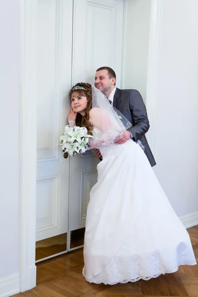 Young wedding Caucasian Russian couple hearing near closed doors — Stock Photo, Image