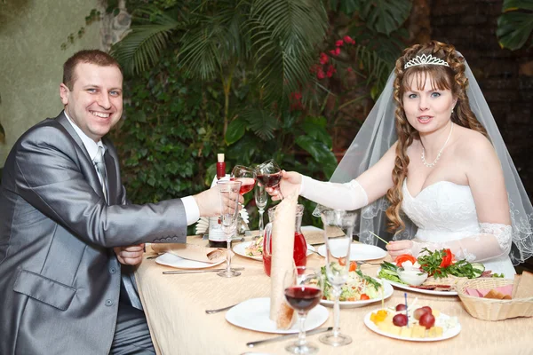 Frisch verheiratete Paare sitzen am Tisch im Restaurant, romantisches Hochzeitsessen — Stockfoto