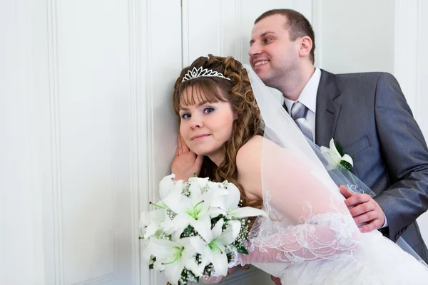 Young wedding Caucasian Russian couple hearing near closed doors — Stock Photo, Image