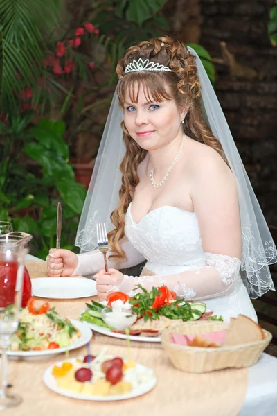 Pengantin wanita yang bahagia duduk di meja restoran mewah — Stok Foto