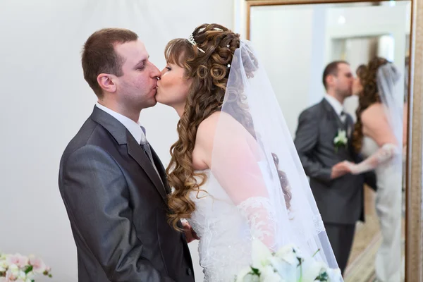 Joven pareja rusa caucásica besando juntos la boda. reflejo en el espejo — Foto de Stock