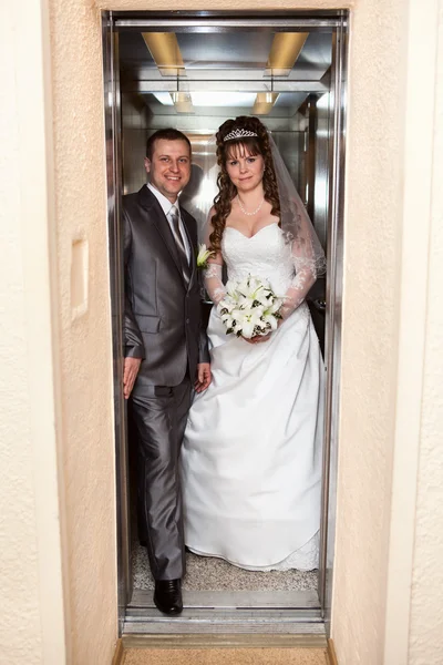 Young wedding Caucasian Russian couple standing in opened doors lift — Stock Photo, Image