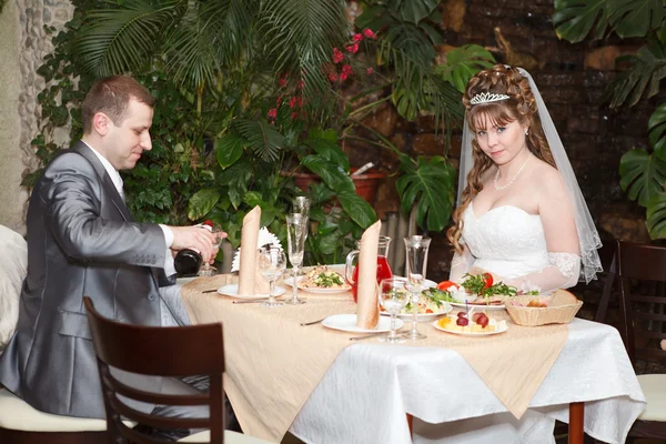 Casal recém-casado sentar-se à mesa no restaurante, jantar de casamento romance — Fotografia de Stock