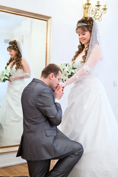 Jonge Kaukasische Russische bruidspaar. bruidegom kussen hand van bruid — Stockfoto