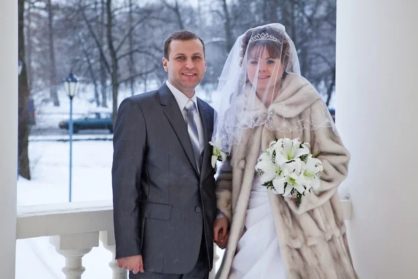 Hermosa pareja recién casada de pie en las escaleras en invierno — Foto de Stock