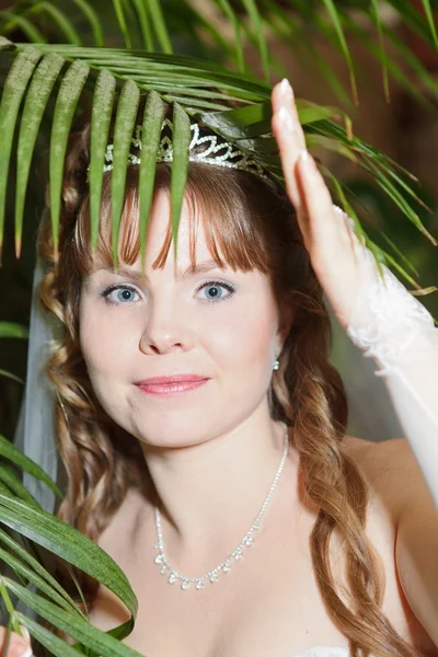 Жінка в короні під пальмовим листом — стокове фото