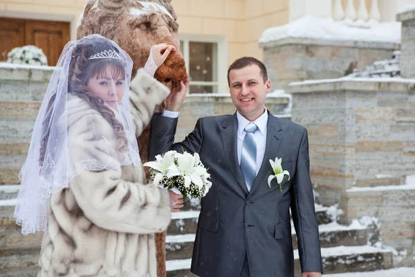 Beau couple russe nouvellement marié prenant des photos avec la sculpture du lion en hiver — Photo