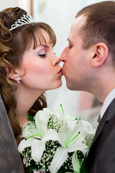 Junge kaukasische Hochzeit russisches Paar küsst sich zusammen und Blumen zwischen — Stockfoto