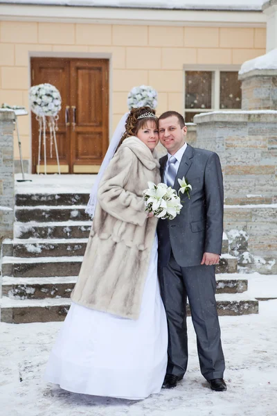 Bonito casal feliz nealy de pé em frente ao edifício no inverno — Fotografia de Stock