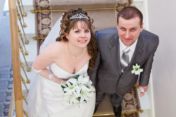 Beau couple nouvellement marié debout sur les escaliers et regardant vers le haut — Photo