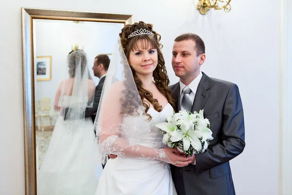 Beautiful newli merried couple in front of the mirror — Stock Photo, Image