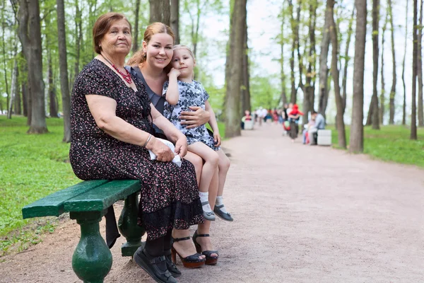 Three women different ages are sitting on bench in park — Stock Photo, Image
