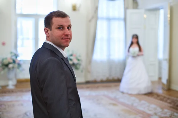 Όμορφος νεαρός χαμογελώντας γαμπρός και νύφη στέκεται σε φόντο — Φωτογραφία Αρχείου