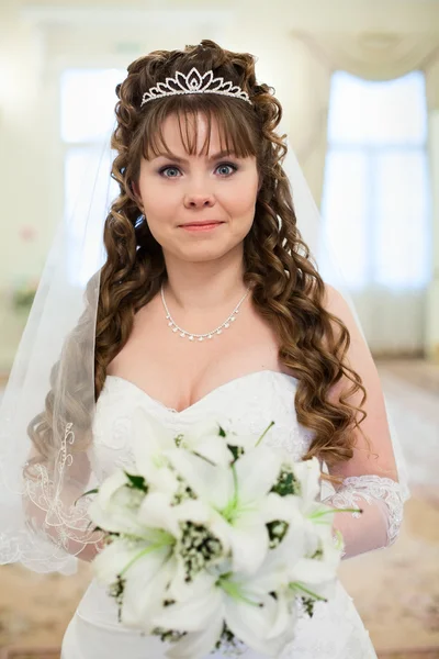 Hermosa novia rusa caucásica en vestido blanco y con flores de lirios — Foto de Stock