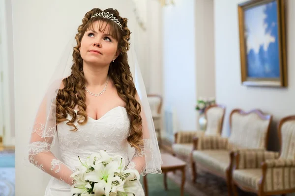 Vackra kaukasiska ryska bruden i vit klänning och med liljor blommor — Stockfoto