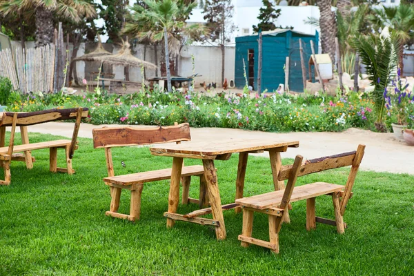 Територія готелю з дерев'яними столами та лавками на зеленій траві — стокове фото