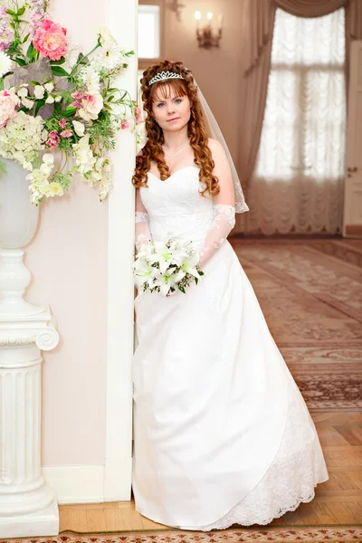 Mooie Kaukasische Russische bruid in witte jurk en met lelies bloemen — Stockfoto