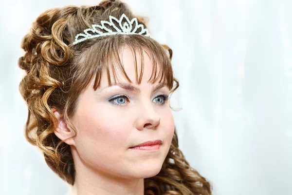 Schoonheid jonge Kaukasische vrouw met krullend haar en kroon op iemand — Stockfoto