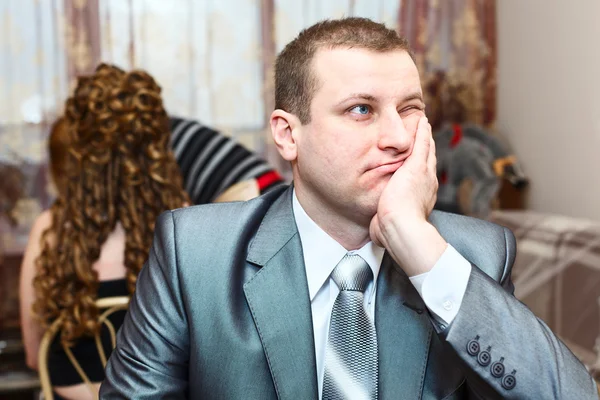 Trött kaukasiska ryska brudgummen väntar på bruden under bröllop preparat i inhemska rum — Stockfoto