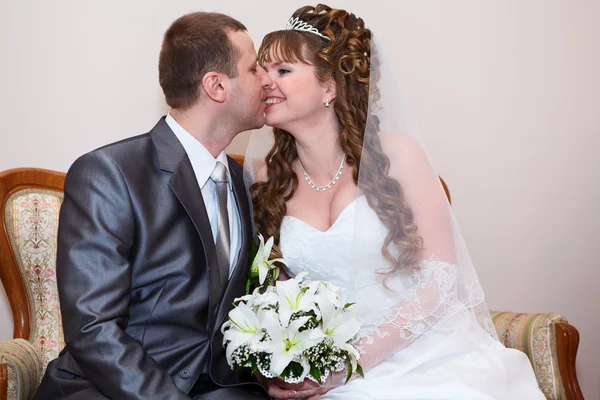 Young wedding Caucasian Russian couple. Bride kissing groom in cheek — Stock Photo, Image