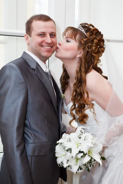 Mladí svatební kavkazské ruský pár. líbání ženicha nevěsta v tvář — Stock fotografie