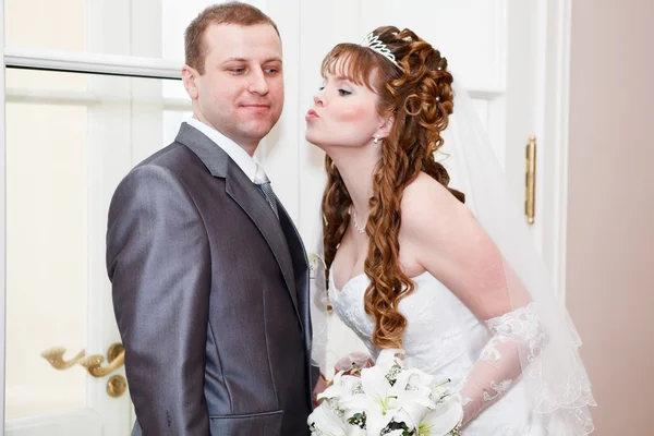 Young wedding Caucasian Russian couple. Bride kissing groom in cheek — Stock Photo, Image