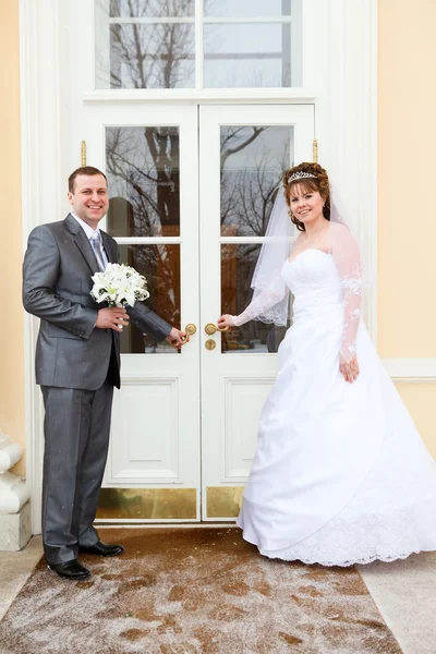 Mladí svatba kavkazské Ruská dvojice stojící před dveře — Stock fotografie