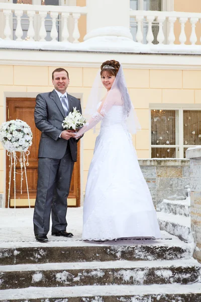 Young wedding Caucasian Russian couple standing in front of the building in winter — Stock Photo, Image