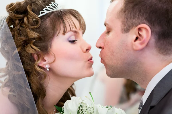 Young wedding Caucasian Russian couple kissing together and flowers between Stock Photo