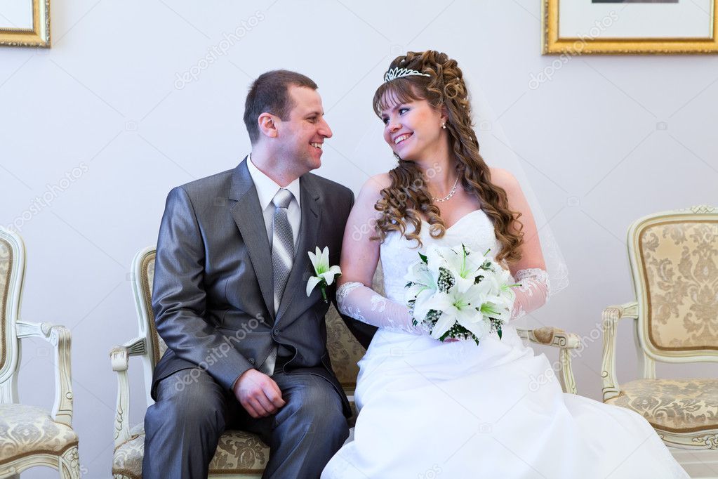Beautiful newly merried man and woman sitting and looking at each other