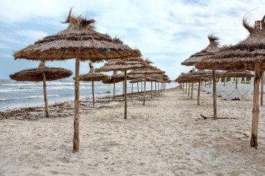 Akdeniz fırtınalı deniz kıyısında ve boş kum plaj şemsiye ile