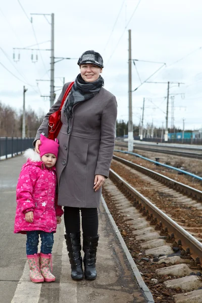Μητέρα και η μικρή κόρη στέκεται στο σιδηροδρομικό σταθμό πλατφόρμα — Φωτογραφία Αρχείου
