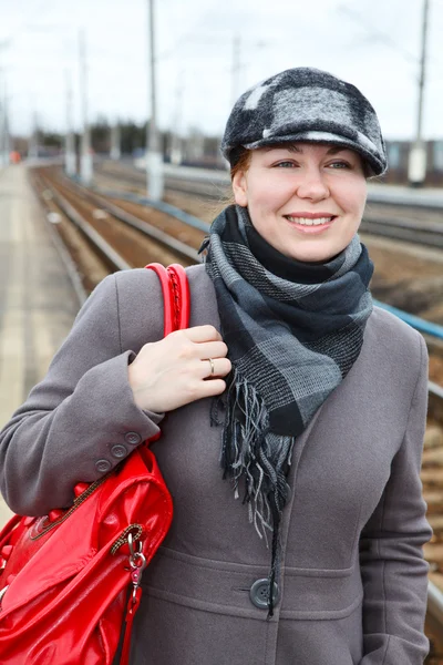 Ritratto di giovane donna in cappotto e cappuccio con borsa rossa — Foto Stock