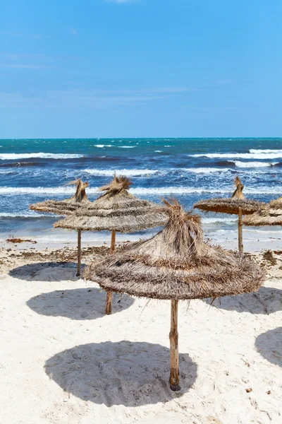 Costa mediterránea de mar tormentoso y playa de arena vacía con sombrillas Costa mediterránea de mar tormentoso y playa de arena vacía con sombrillas —  Fotos de Stock