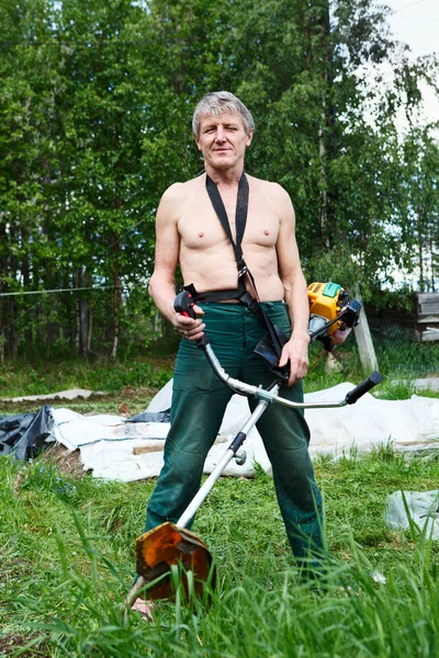 Homem maduro um cortador de grama com cortador de grama cortador de helicóptero . — Fotografia de Stock