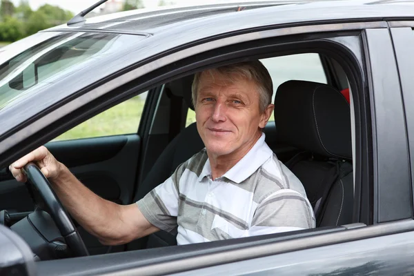 Happy senior person sitting in car on driver seat — Stock Photo, Image