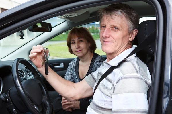 Senior Caucasian male and woman sitting in land vehicle and smiling — Stock Photo, Image