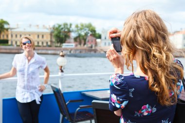 Woman photographer photographing her girlfriend with simple camera clipart