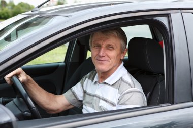 Happy senior person sitting in car on driver seat clipart