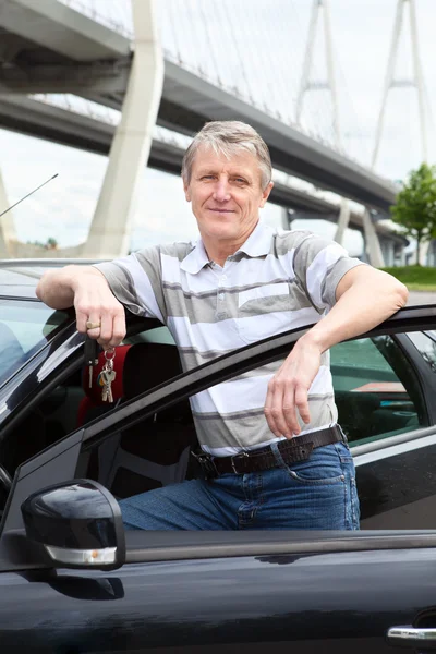 Happy mature driver with ignition key — Stock Photo, Image