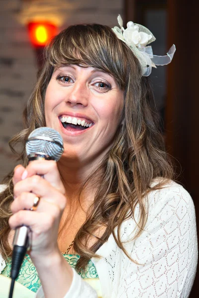 Mutlu çekici kadın şarkıcı mikrofon holding olarak — Stok fotoğraf