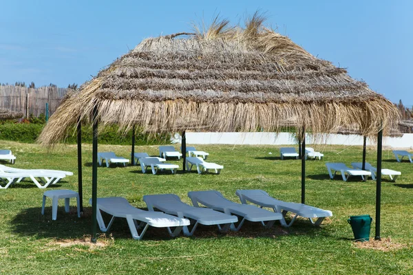 Território de Hotel, com camas de sol plástico branco na grama verde — Fotografia de Stock