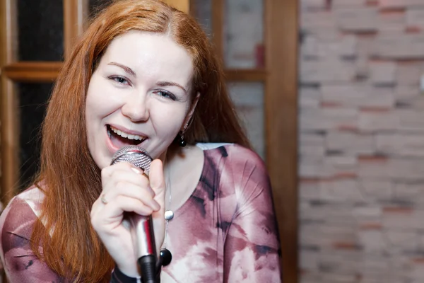 Νεαρή γυναίκα ένας τραγουδιστής τραγουδά ένα τραγούδι με μικρόφωνο. copyspace — Φωτογραφία Αρχείου