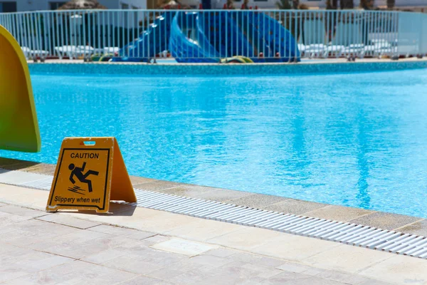 Znak śliskie podłogi przy basenie — Zdjęcie stockowe