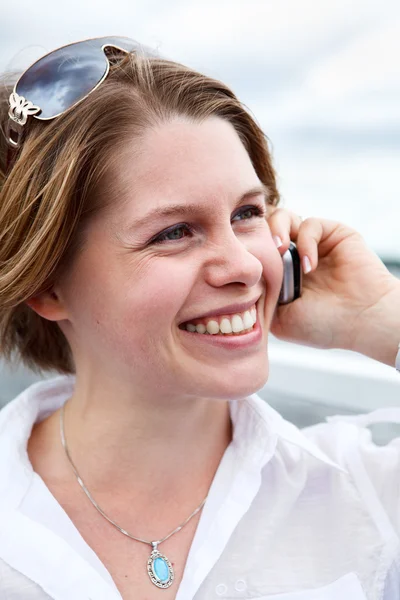 Mulher feliz em camisa branca com óculos de sol chamando no celular. Fechar — Fotografia de Stock