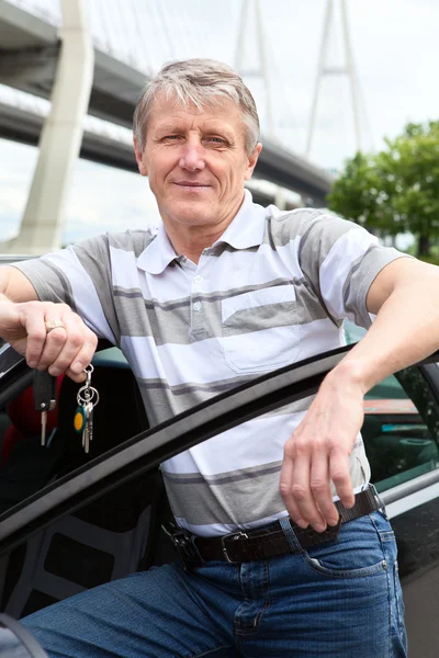 Mogna driver med tändning nyckel står nära bilen — Stockfoto