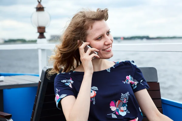 Hablando en la mujer del teléfono móvil en vestido en la cafetería del barco — Foto de Stock