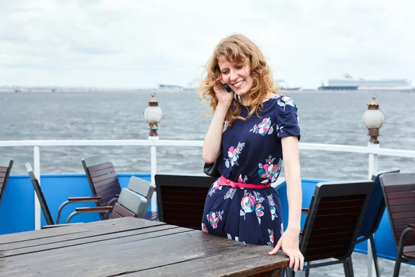 Mujer de pie en la cubierta del barco con teléfono móvil — Foto de Stock