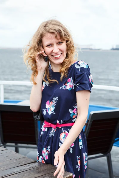 Vrouw bellen door mobiele in schip dek café — Stockfoto